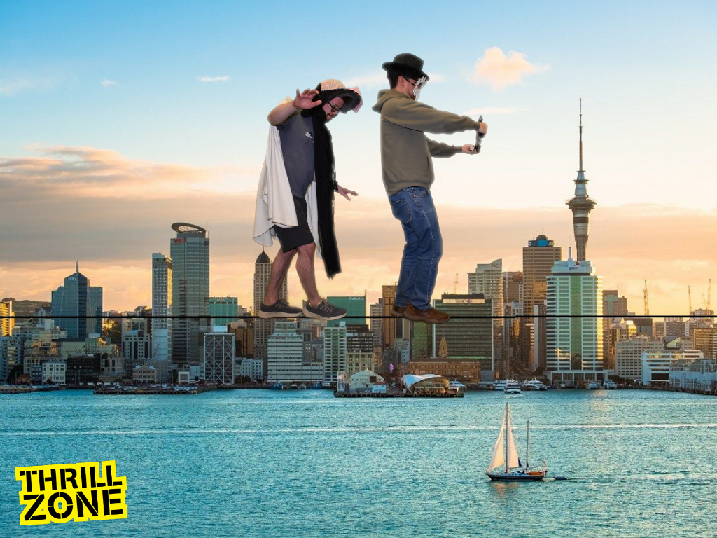 Two costumed idiots tightrope walking against the Auckland skyline.